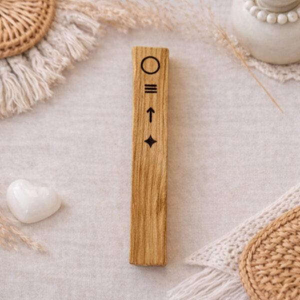 Bâton en Palo Santo gravé de symboles liés aux intentions de la nouvelle lune, dans une ambiance naturelle et bohème